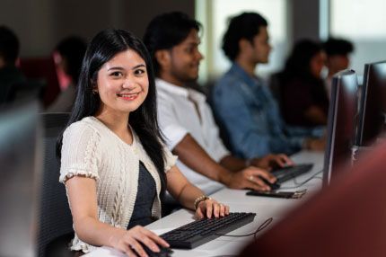 Happy woman works in computer lab