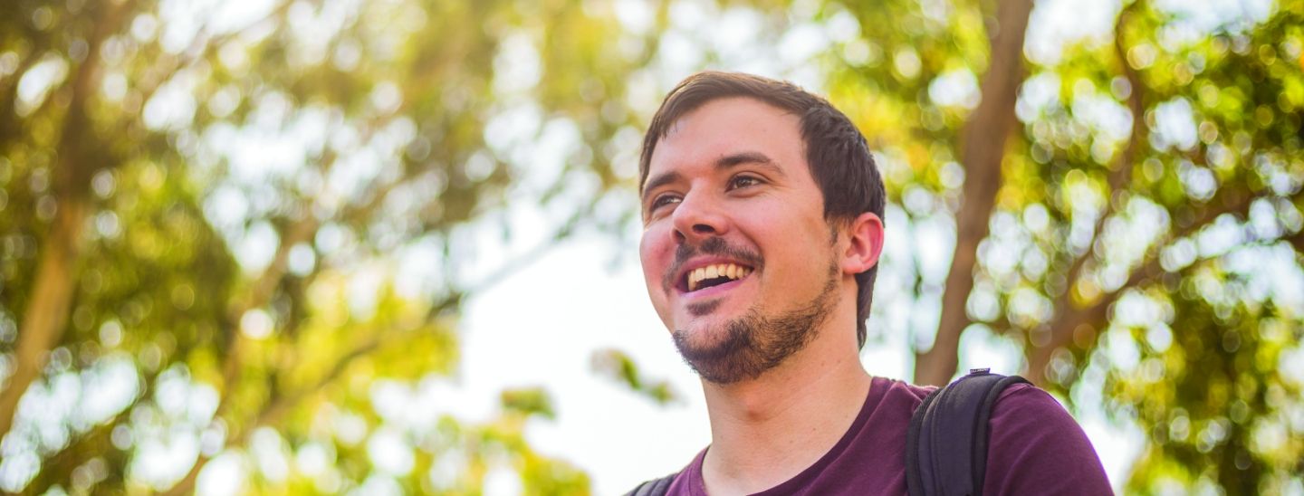 Male student outside happy