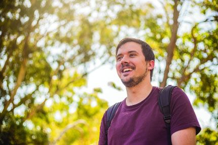 Male student outside happy