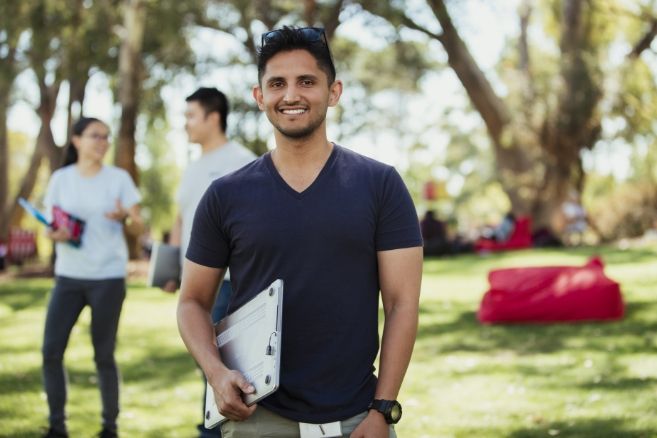 Man holding laptop outside