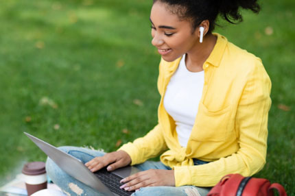 Woman studying outside on grass